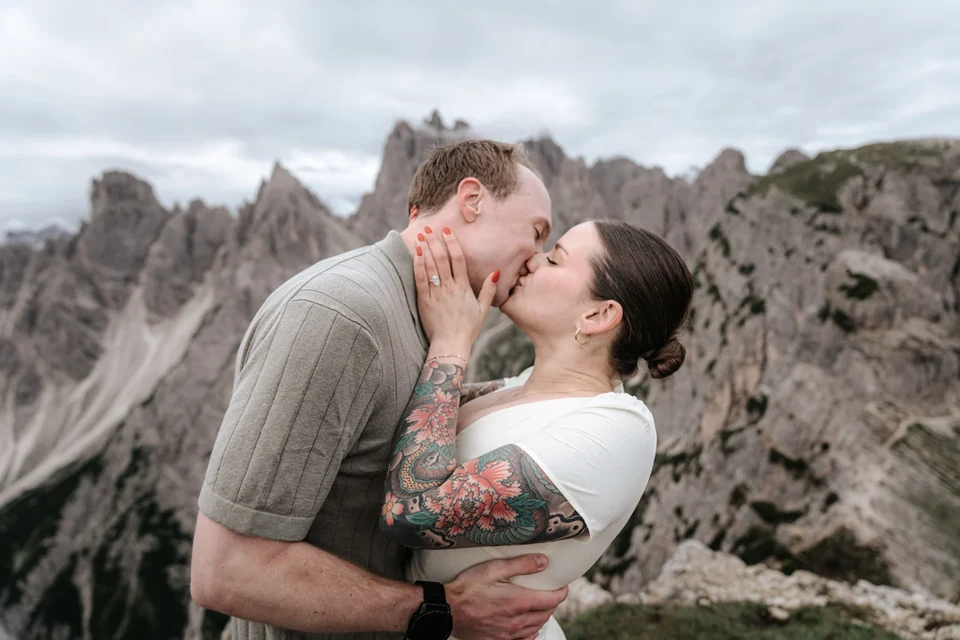 A kiss under a moody, dramatic Dolomite sky