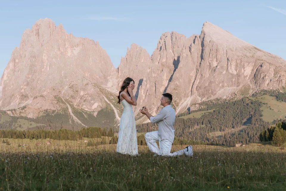 Kneeling to propose on the Alpe di Siusi, the Sassolungo behind