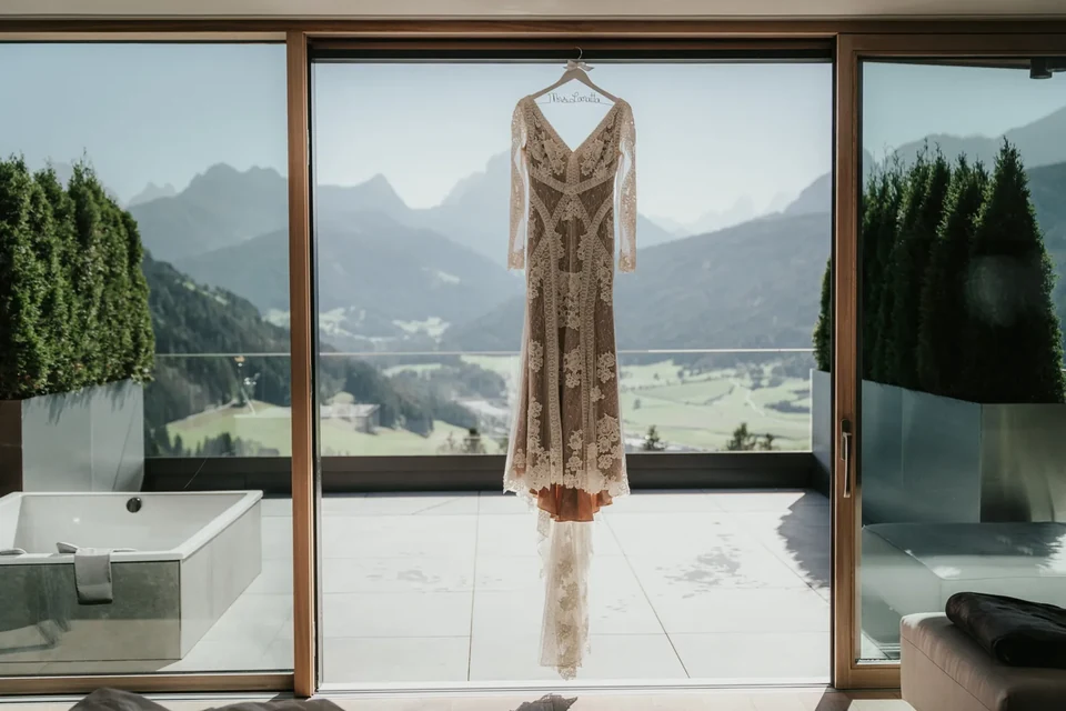 L'abito da sposa appeso davanti a una finestra piena di montagne