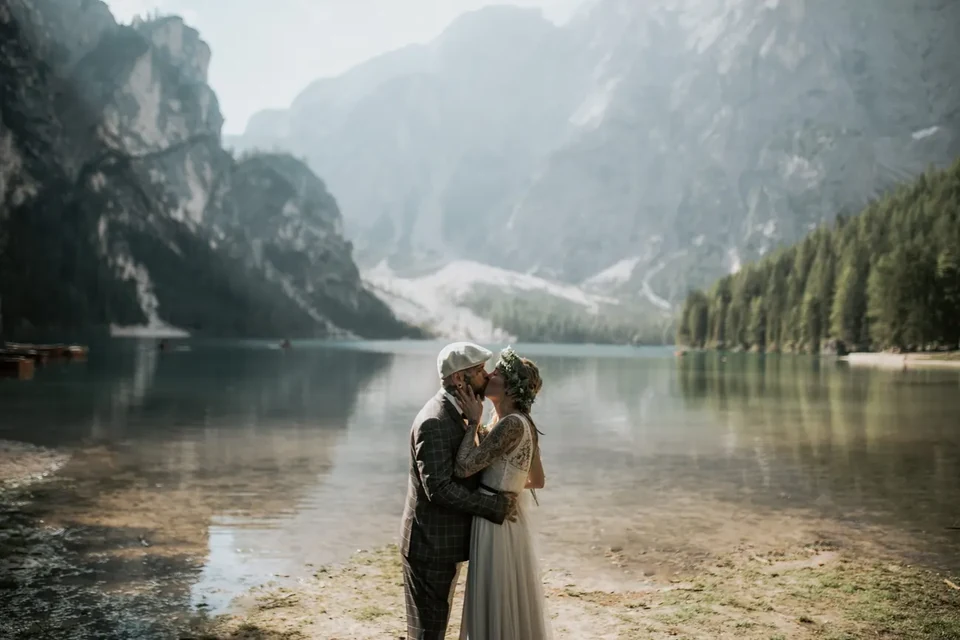 Una coppia abbracciata a un nebbioso lago dolomitico nel giorno del loro elopement
